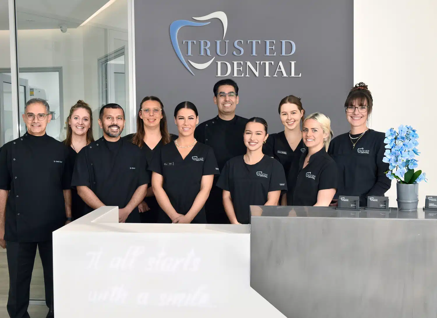 Trusted Dental Team photo in front of logo